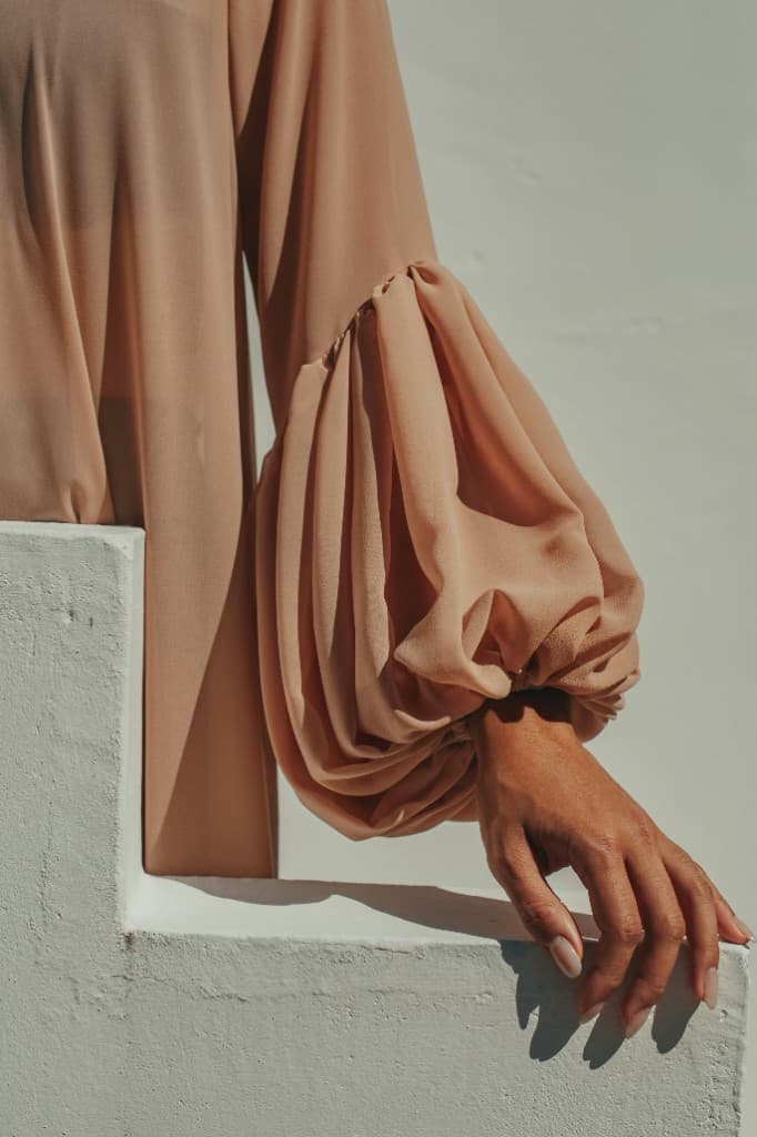 Elegant sheer sleeve fashion editorial on a white background